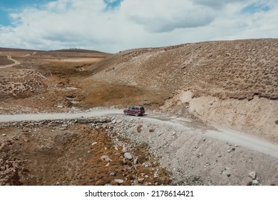 Red Suv Driving Off Road In Mountain Plains Of Deosai National Park On Sunny Day In Pakistan