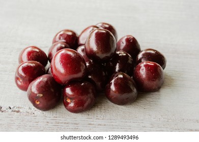 
red sweet cherry on a light wooden background