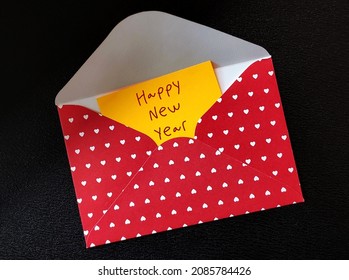 Red Sweet Heart Envelope With Yellow Note Written HAPPY NEW YEAR, Concept Of Warm Wishes For New 2022 Year, Greeting Card Sending Happiness To Love Ones In Holiday Season