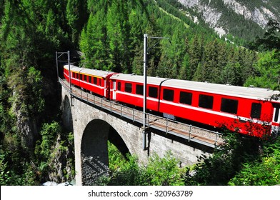 Red Swiss Train On Viaduct, Switzerland