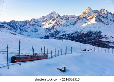 Red Swiss Train Running Through The Snow