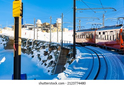 Red Swiss Train Running Through The Snow