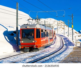 Red Swiss Train Running Through The Snow