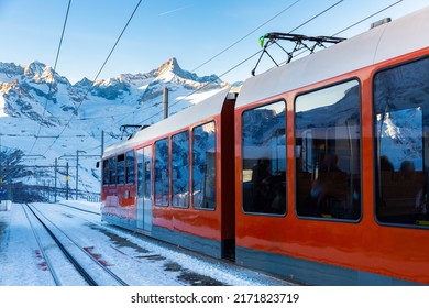 Red Swiss Train Running Through The Snow