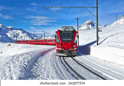 A Red Swiss Train Running Through The Snow, Switzerland