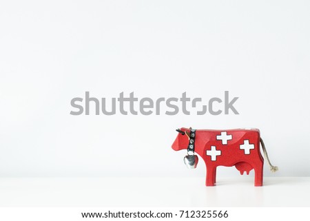 Red swiss wooden cow on white background. Souvenir