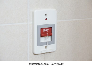 A red switch calling for emergency help in the toilet
