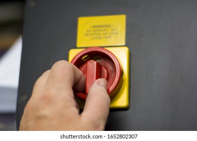 a red switch on a printing machine for on and off working mode