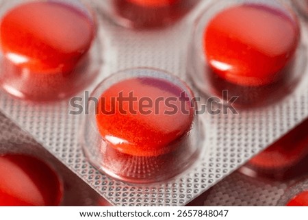 Red tablets in a blister, macro. Concept of sedative tablets and sleeping pills