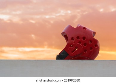 Red Taekwondo Head Guard With  On Sunset Background.