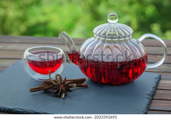 Red tea with spices in a teapot and a cup. Hibiscus
tea. Tea party