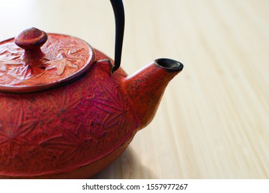 Red teapot on bamboo counter