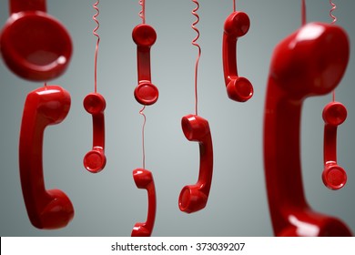 Red telephone receiver hanging over gray background concept for on the phone, on hold or contact us