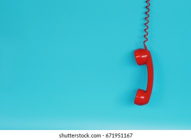 Red telephone receiver over blue background color with copy space - Shutterstock ID 671951167