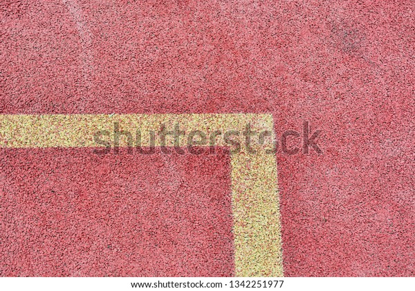 Red\
tennis court with yellow markings on field for\
game