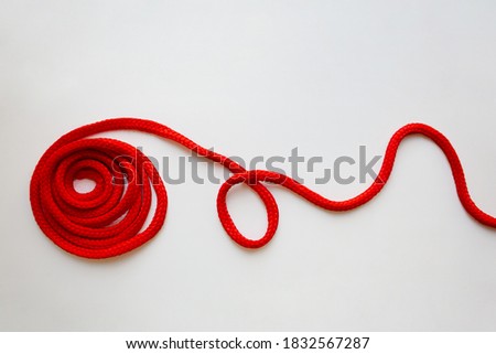 Red textured cord roll with curved line isolated on white background