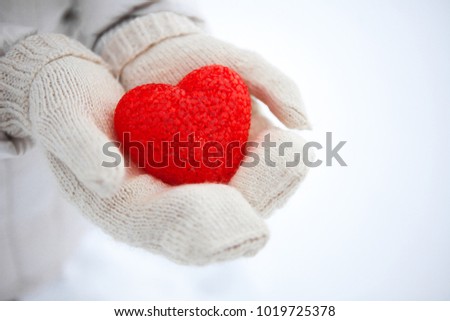 The red textured heart lies on the palms. I give you heart. Valentine's Day.