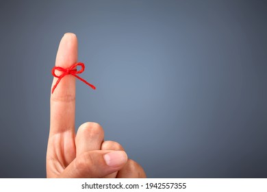 Red thread bow on a human finger
