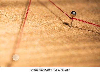 Red Thread Connects Pins On Cork Board, Soft Focus