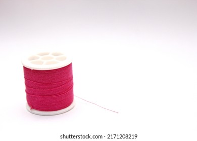 The Red Thread Spool Is Placed On A White Background.