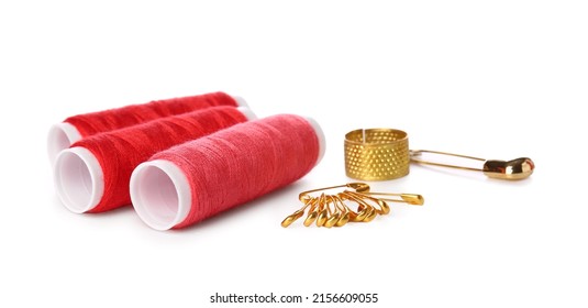 Red Thread Spools, Safety Pins And Thimble On White Background