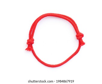 Red thread, string as amulet for wrist isolated on white. Red bracelet with knots. Top view.