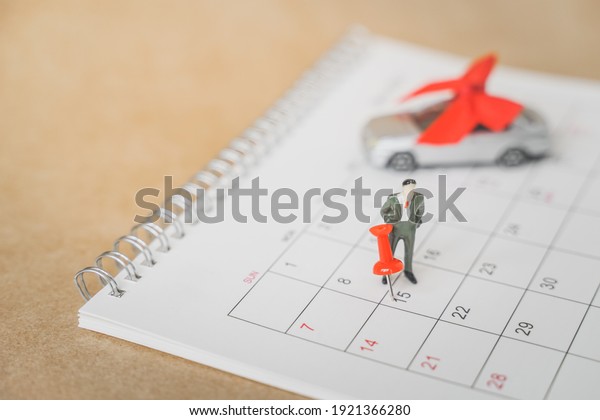 red thumbtack  marked on 15th\
of month and miniature business man on white calendar with blurred \
 small car on grunge brown paper, new car, goal, due date\
concept