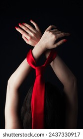 Red tie around the wrist of a woman from behind