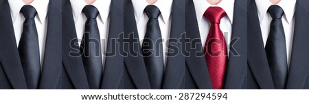 Red tie between black neckties as stand out of the pattern or crowd concept