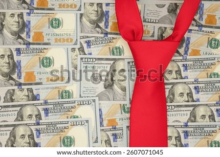 Red tie on dollars background. American trade policy. New tariff regime. Copy space.