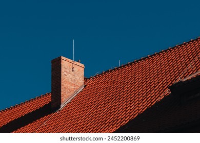 red tile roof with chimney against the sky  - Powered by Shutterstock