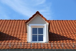 A Red Tile Roof On A Residential House With Dormers