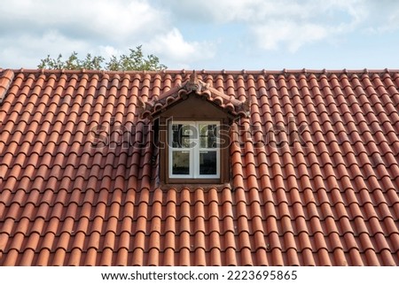 Red tiled roof with attic. Dormer window white color on garret, rooftop. Cloudy sky background. ストックフォト © 