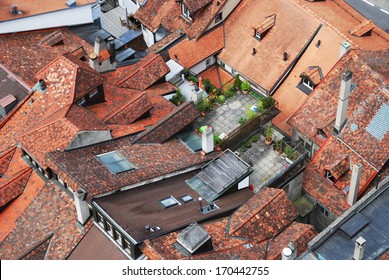 Red Tiled Roofs Of Townhouses Tightly Adjacent To Each Other. There Are Several Roof Gardens Among Them. The Old City Of Fribourg Is Photographed From Above. 