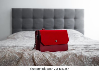 Red Tiny Bag Purse On The Bed. Little  Handbag On Comfortable Bedroom Couch.