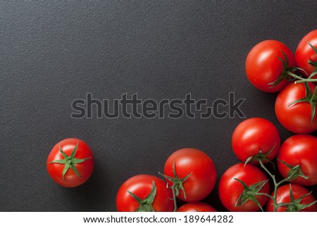 red tomatoes on black. top view