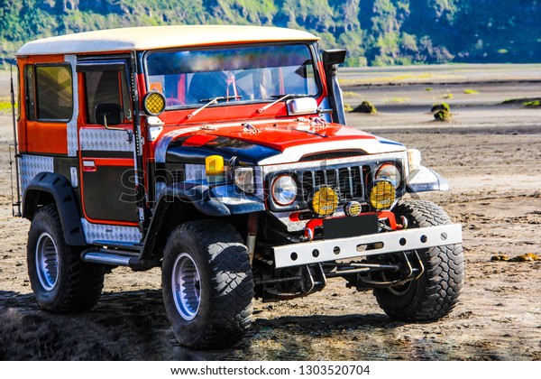 Red touring car in the Bromo volcano,\
Innodonian region,\
12/12/2011
