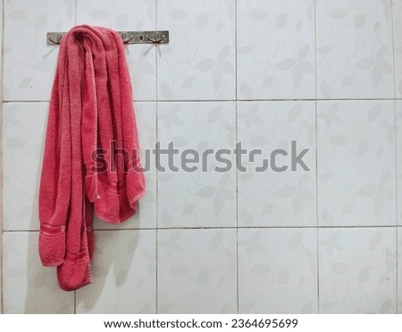 red towel hanging on the wall, in the bathroom