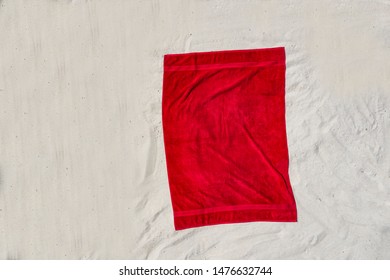 Red Towel On A Sandy Beach On A Sunny Summer Day.