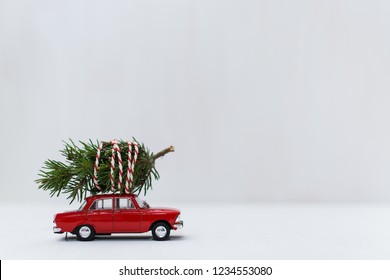 Red Toy Car With A Christmas Tree On The Roof, White Background, Shallow Depth Of Field.