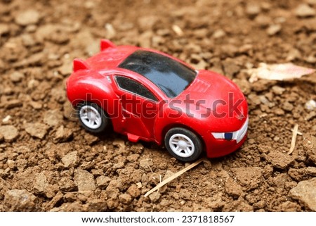 red toy car on the ground. children, children's toys.