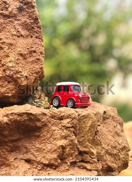Red toy car on a\
rock