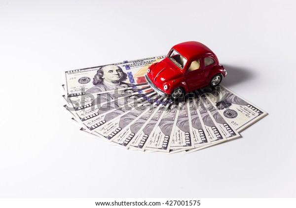 Red toy car with some\
dollars.