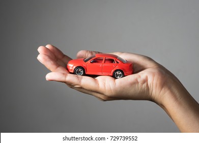 Red toy car in woman hand.