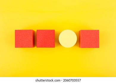 Red Toy Cubes And Yellow Circle In A Row On Bright Yellow Background. Concept Of Individuality, Being Different From Others, Leadership Or Unique Ideas 