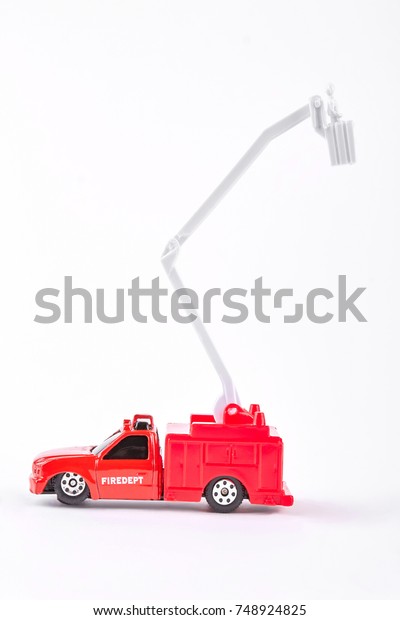 Red toy fire truck, white\
background. Plastic model of fire lorry isolated on white\
background.