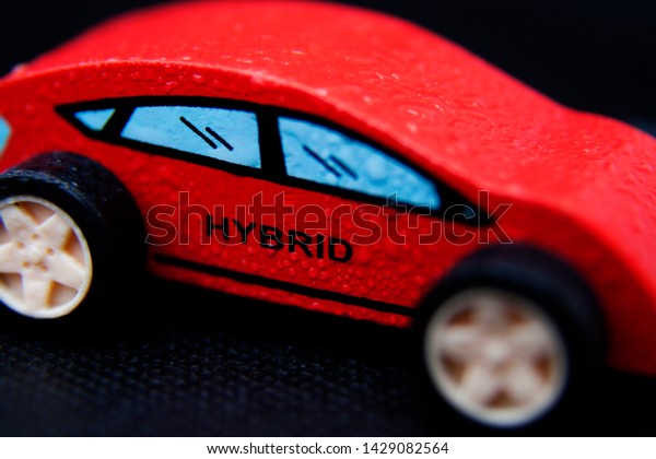 red toy hybrid car in\
wood