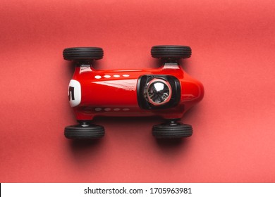 Red toy racing vintage car on a red background