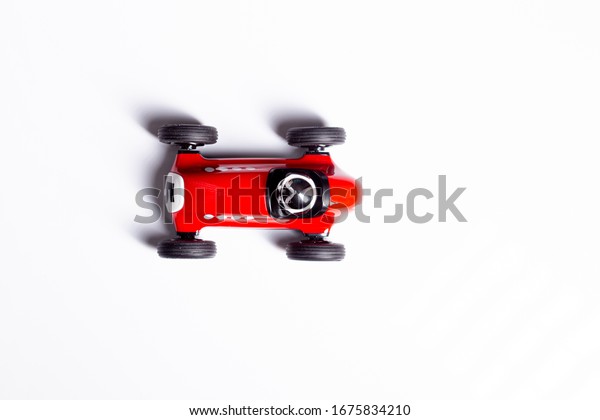 Red toy vintage racing car close up still\
isolated on a white\
background