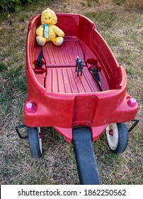 A Red Toy Wagon With A Yellow Stuffed Duck And A Toy Horse Riding In The Back Of The Wagon